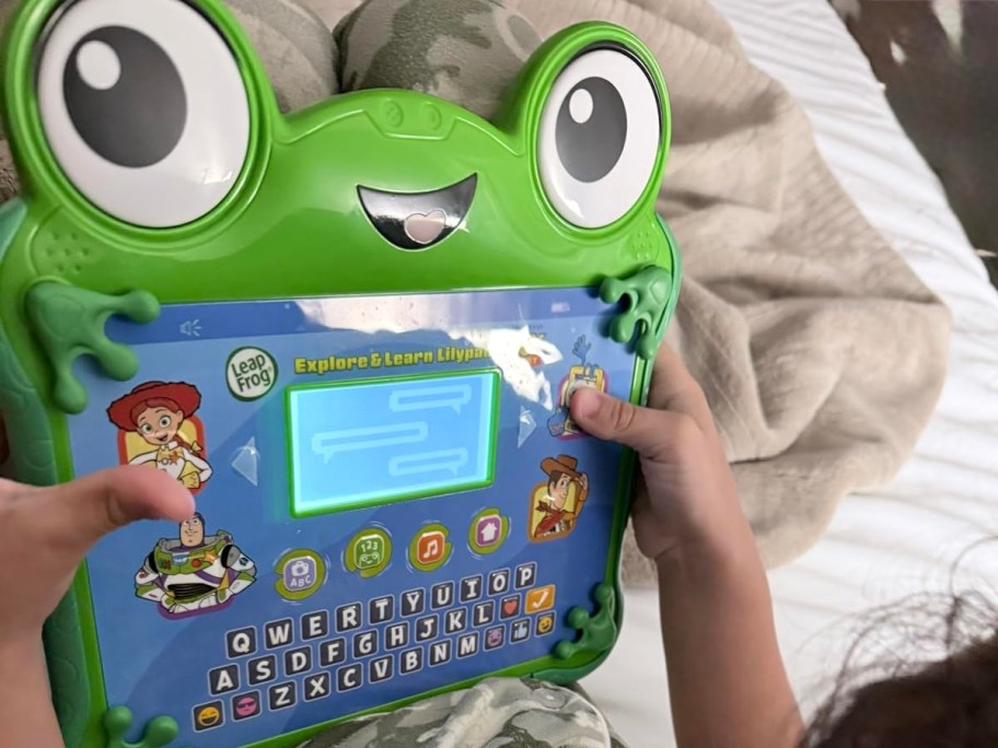 child holding Toy Store themed leapfrog tablet