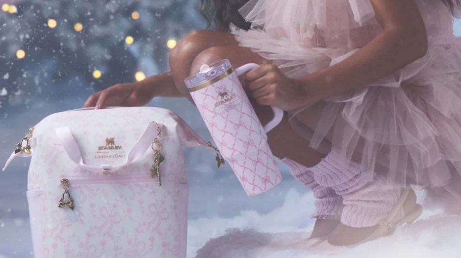 a woman holding a pink stanley cup