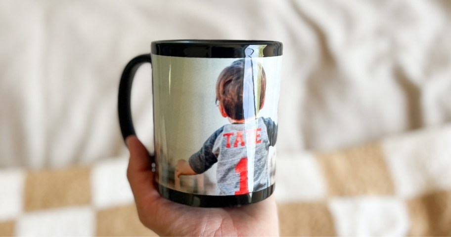 a womans hand holding a custom photo mug