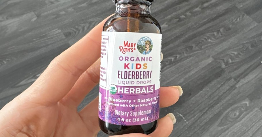 hand holding bottle of elderberry supplement