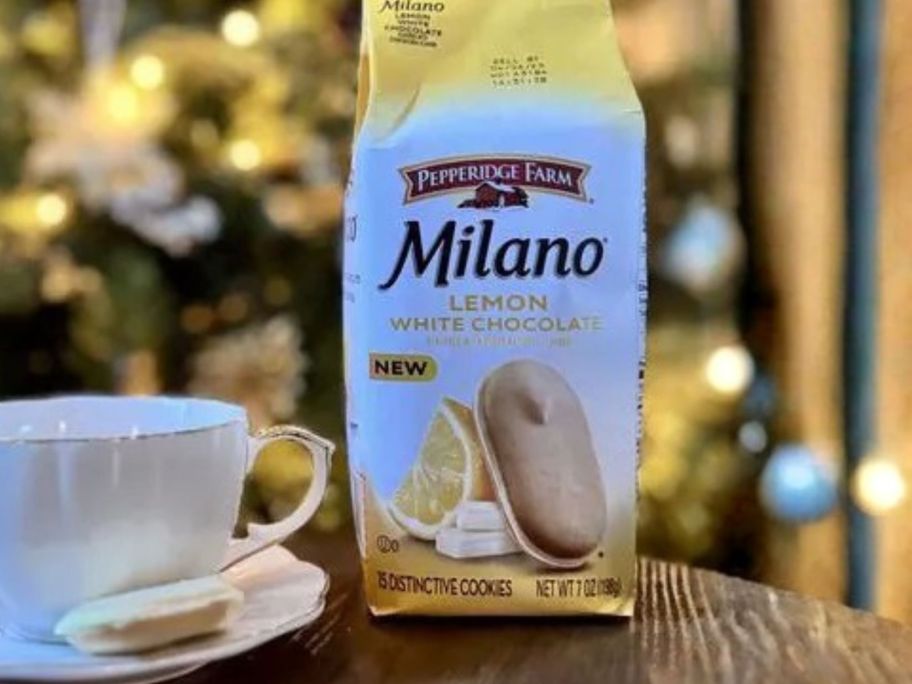 Pepperidge Farm Milano White Chocolate Lemon Flavored Cookie bag on table with cup next to it and christmas tree in background