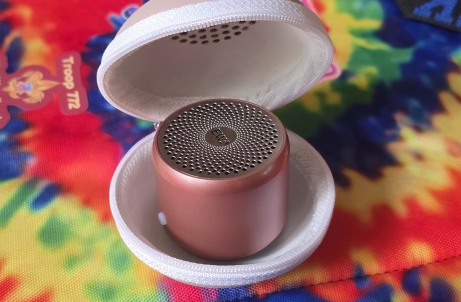 close up of mini pink speaker on tie dye sheet
