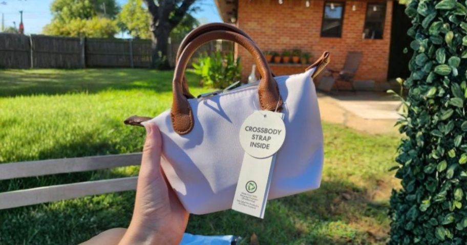 hand holding white and brown mini tote bag