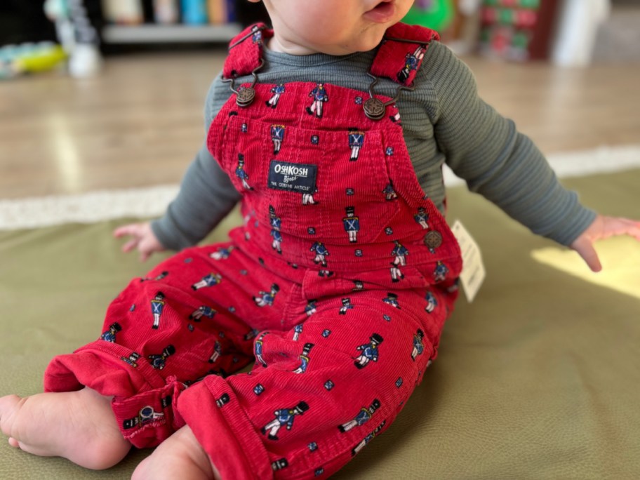 baby wearing osh kosh overalls