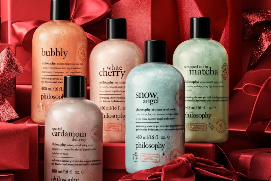 five different colored shimmery shower gel bottles on red silk 