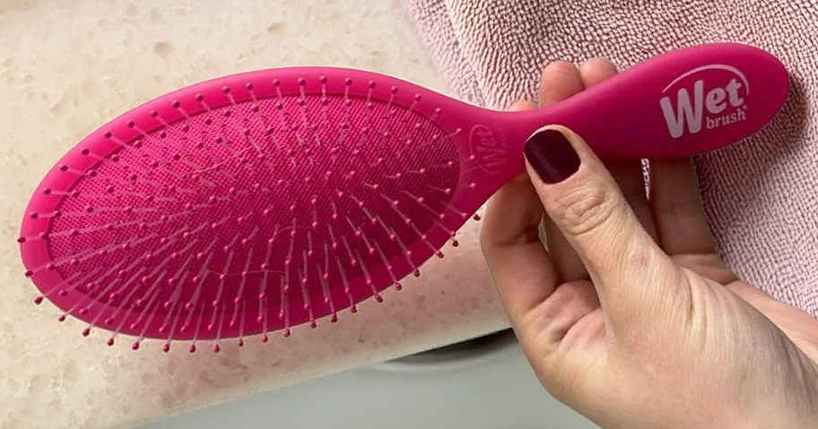 person holding pink wet brush