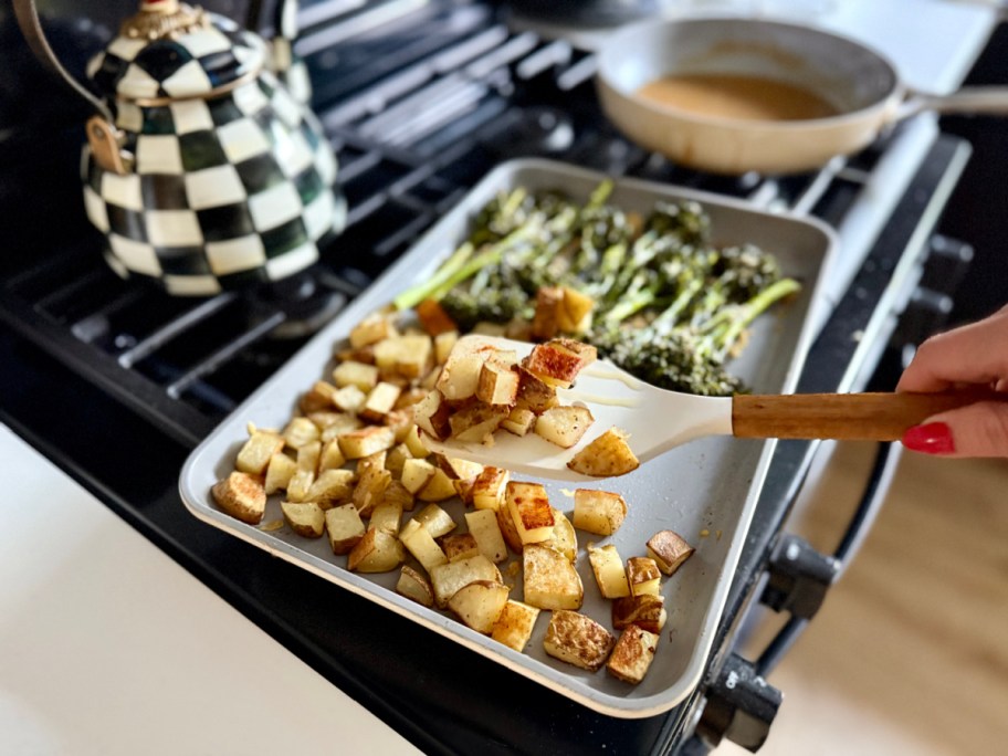 pan of roasted potatoes and broccoli on a stovetop
