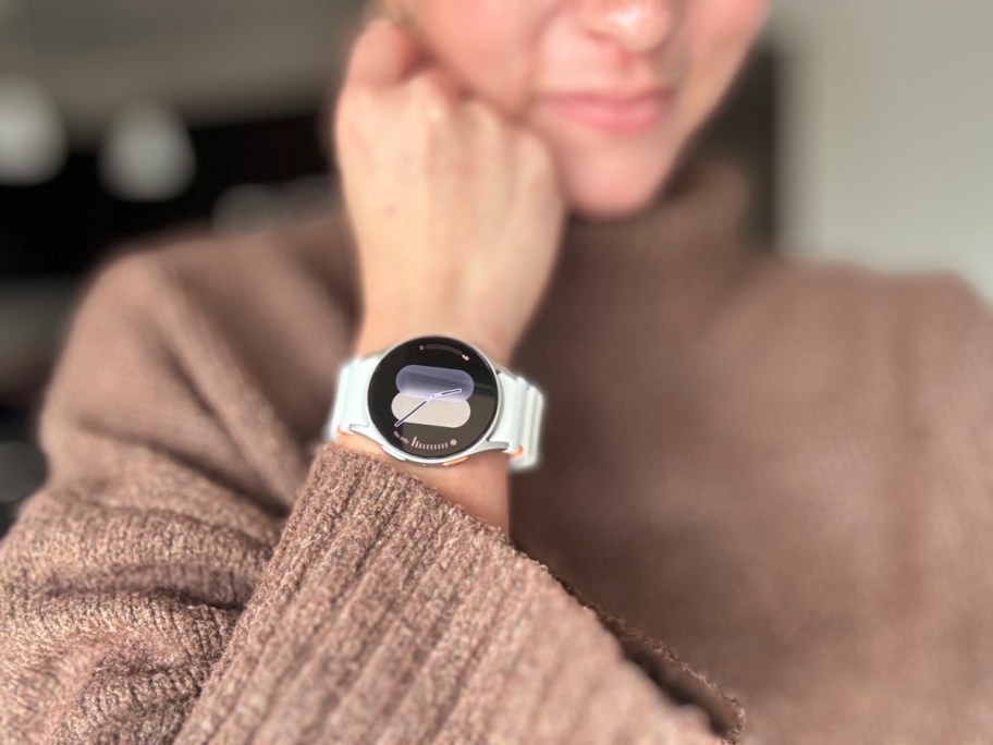 woman wearing a smart watch with her arm bent and hand against her chin
