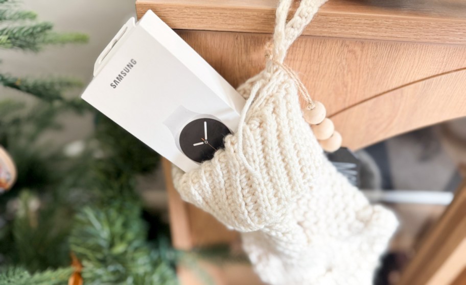 samsung galaxy watch box tucked into a white christmsa stocking hanging on the mantle