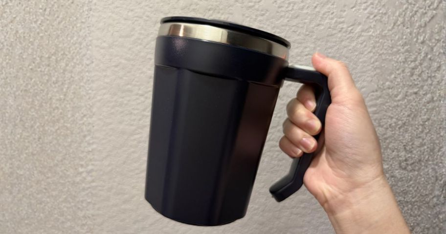 hand holding self stirring mug