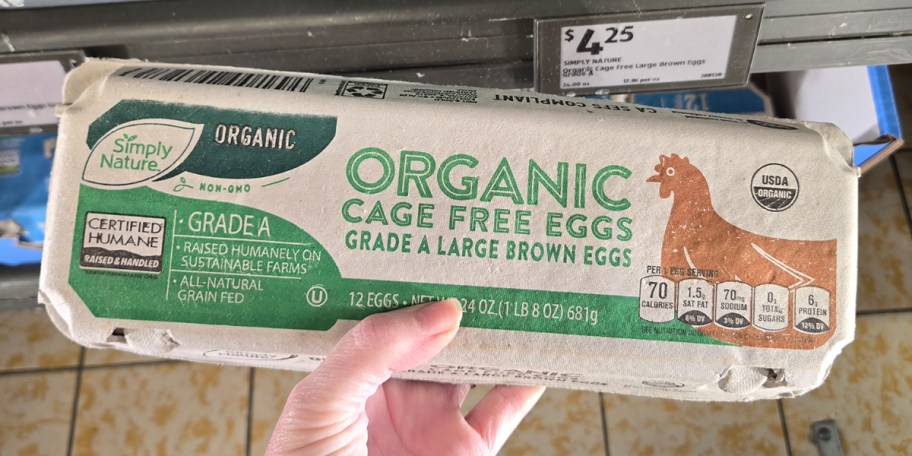hand holding carton of organic eggs 