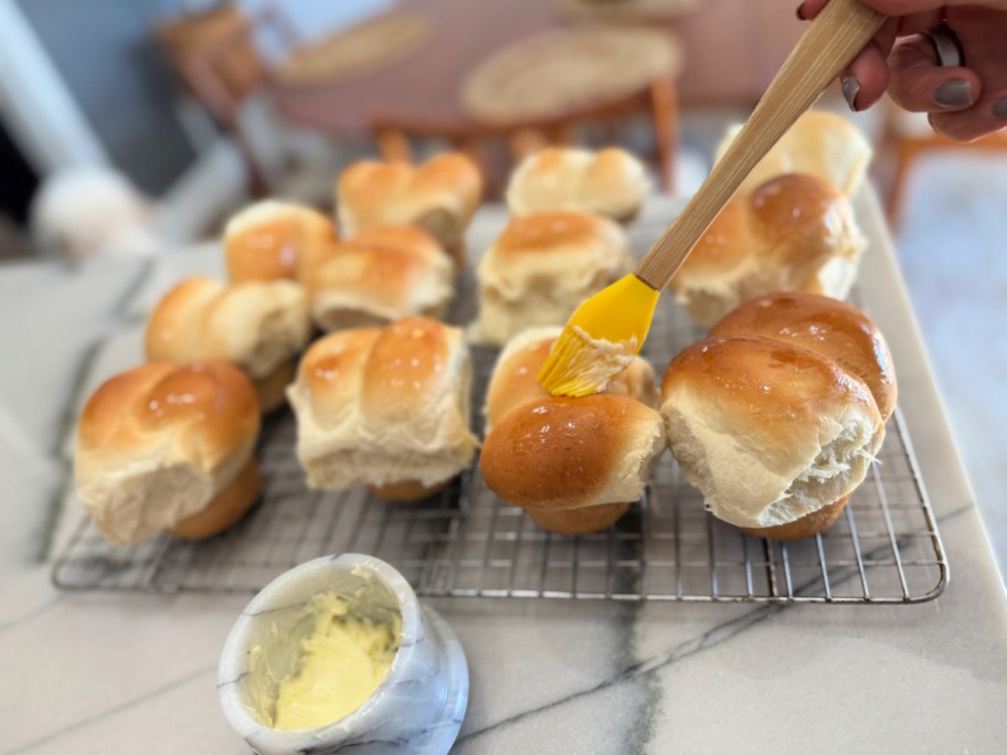spreading butter on muffin pan rhodes rolls 