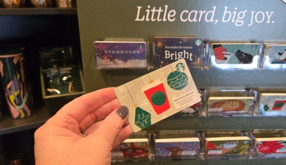 a womans hand holding a starbucks giftcard