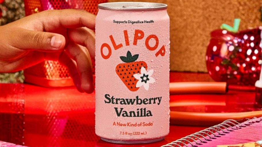 mans hand reaching for a mini can of olipop soda