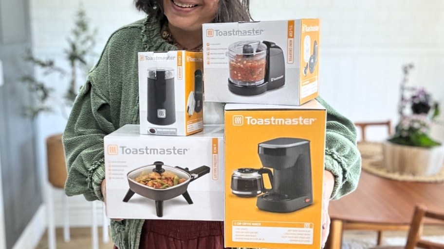 a woman holding 4 toastmaster mini appliances