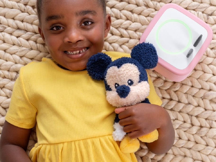 young girl with a plush mickey toy