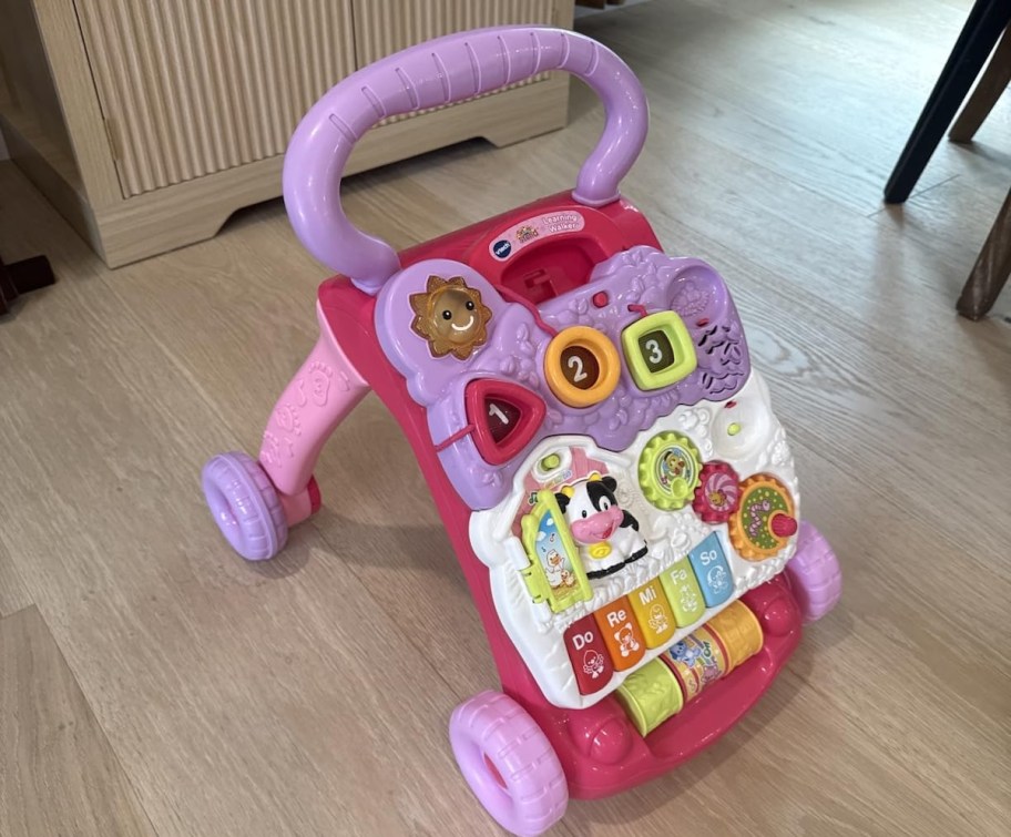 pink activity walker on wood floor