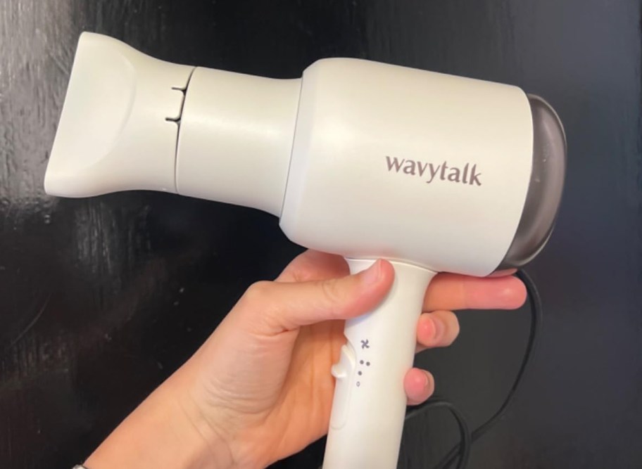 person holding a white hair dryer