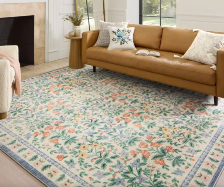 blue and pink floral area rug under tan couch