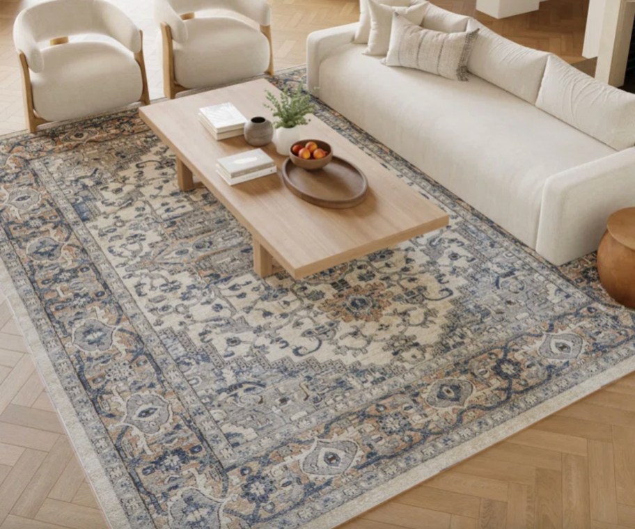 blue and cream oriental rug under beige couch
