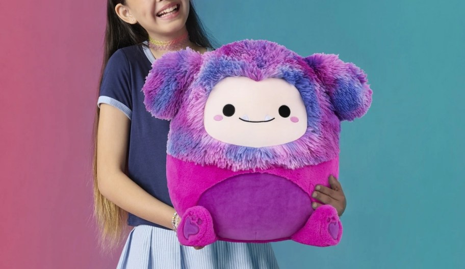 a girl holding a 16" inch squishmallow