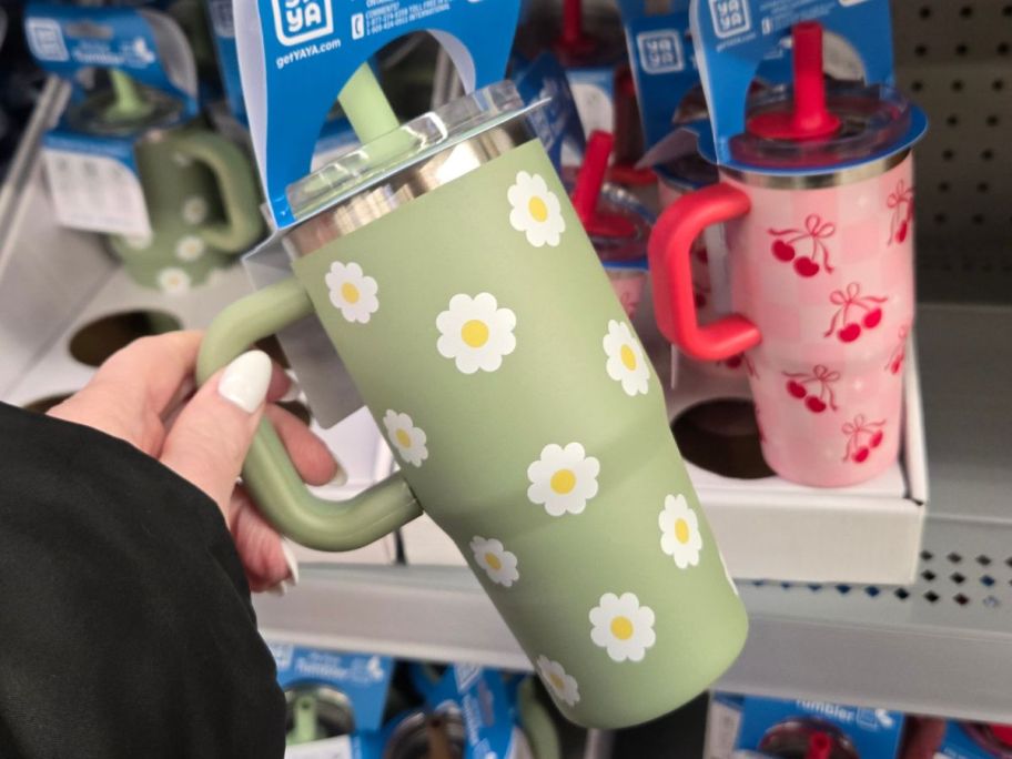 hand holding yaya tumbler with daisies on it in store