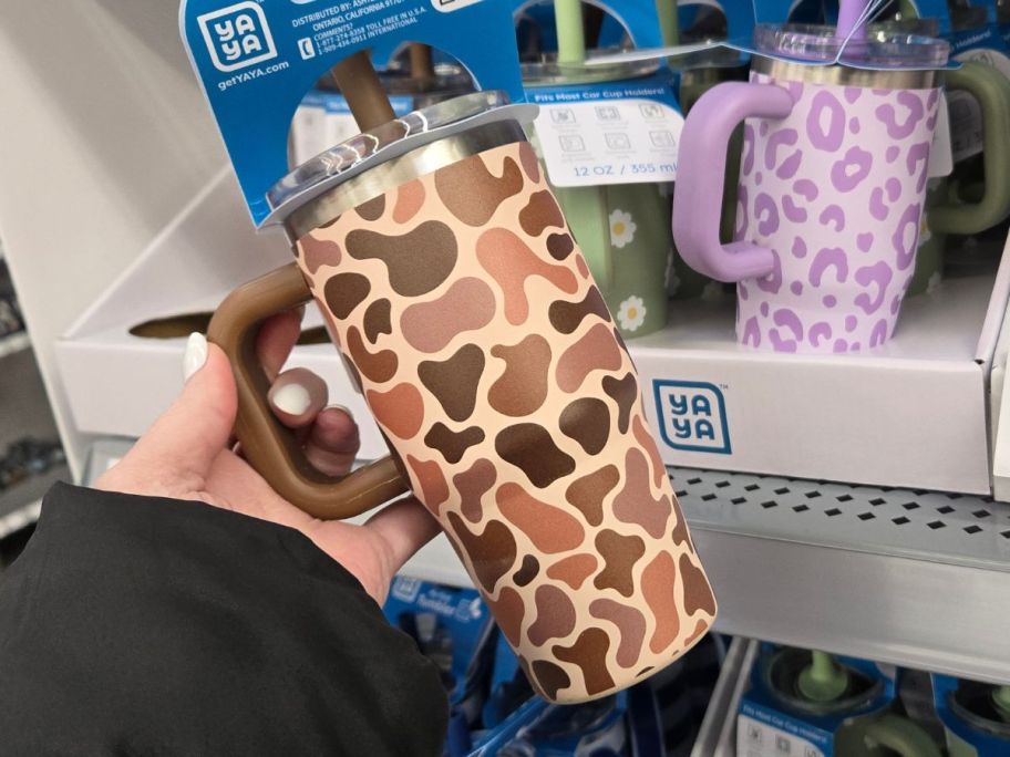 hand holding yaya tumbler with a camo design on it in store