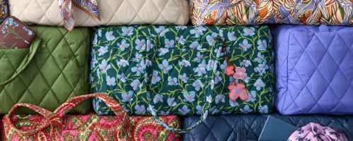 stack of Vera Bradley duffel bags in different patterns