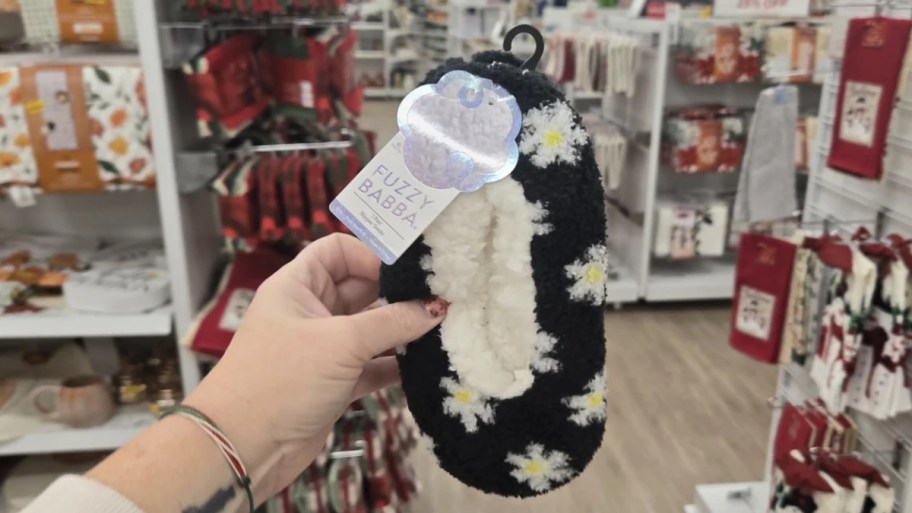 womans hand holding a pair of 9) Fuzzy Babba Kids Slipper Socks