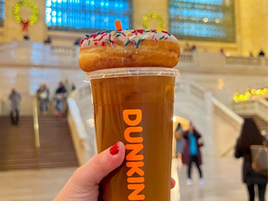 A donut on top of a Dunkin Iced Coffee