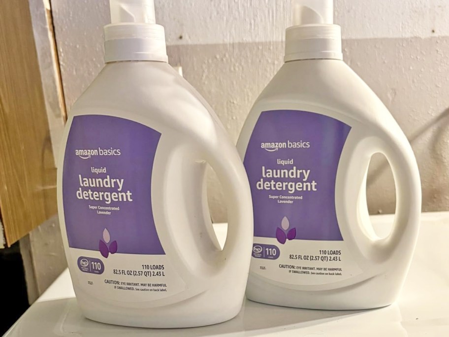 two white and purple bottles of Amazon Basics Laundry Detergents