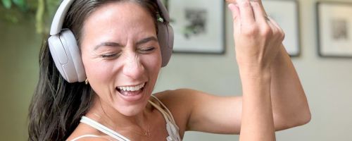 Woman wearing headphones while rocking out to music