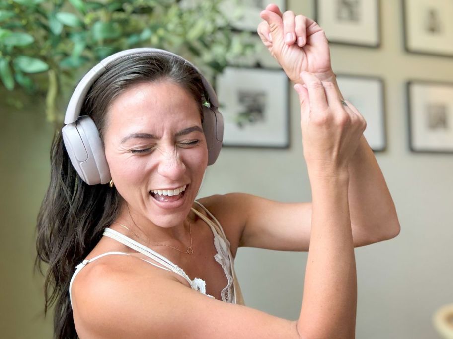 Woman wearing headphones while rocking out to music