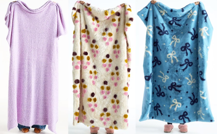 three women holding up throw blankets