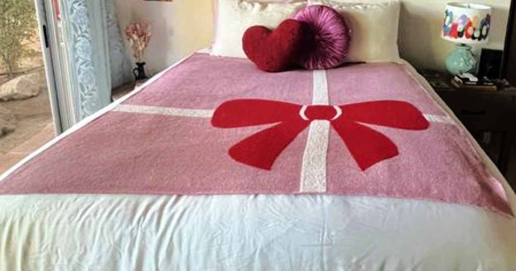 Red and pink bow blanket draped on bed
