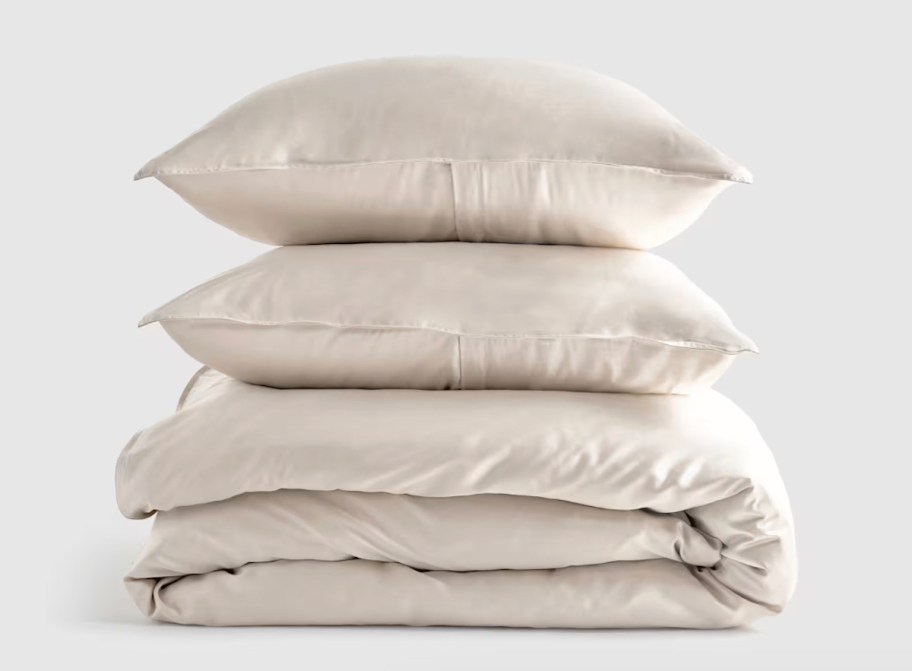 stack of cream colored bedding and pillows