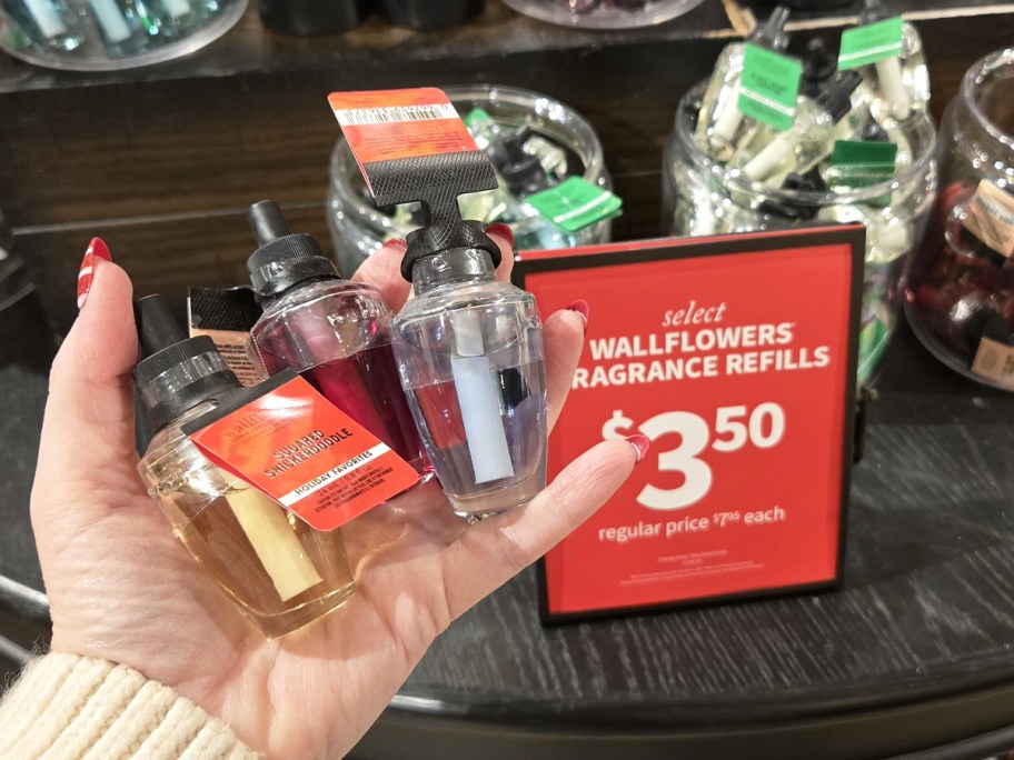 hand holding 3 Bath & Body Works Wallflower Refills