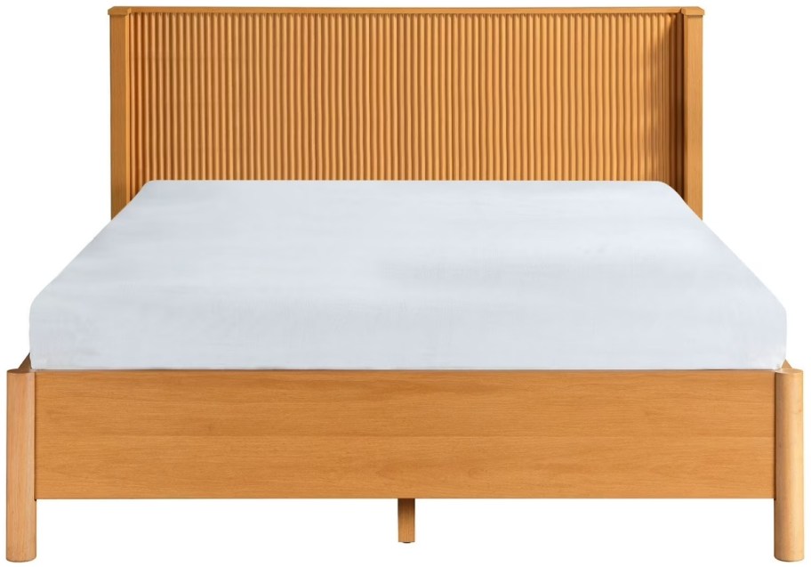 a queen sized platform bed with fluted headboard