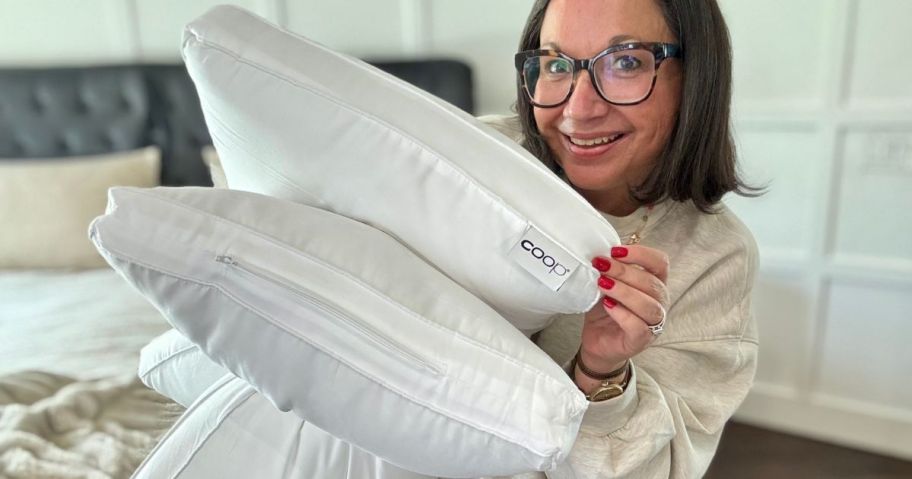 Woman holding two Coop pillows