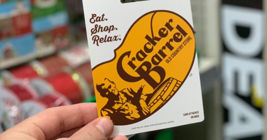 Person holding a Cracker Barrel gift card in hand while in store