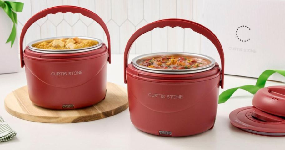 2 red food warmers with soup inside of them