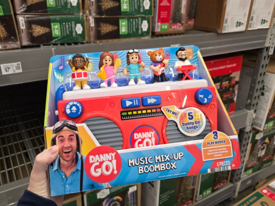 A hand holding up a Danny Go! Boombox toy at Walmart.