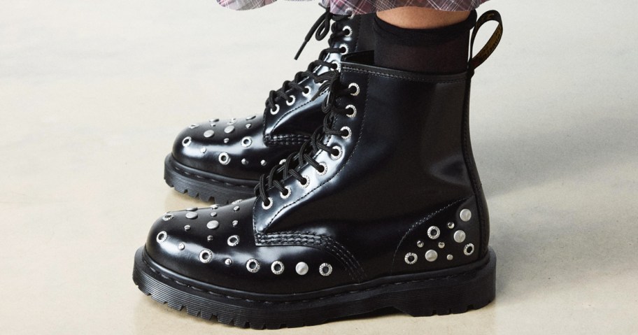 person wearing black studded leather boots