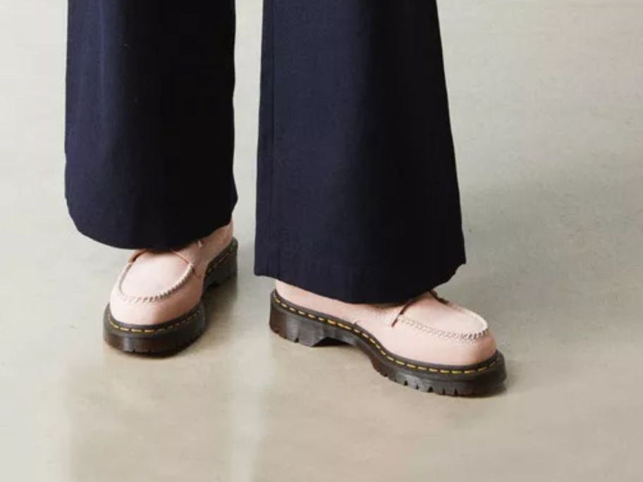 A person wearing pink moc toe shoes