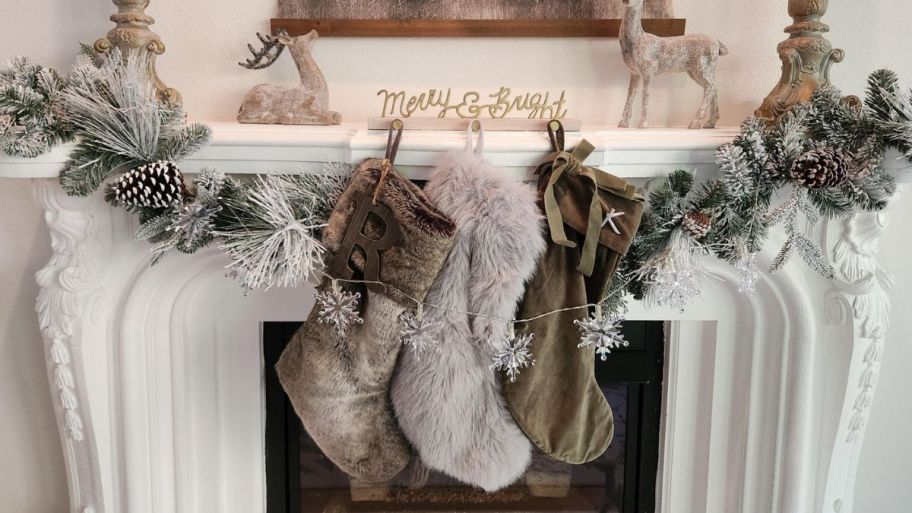 Garland with pinecone and stockings displayed on the fireplace