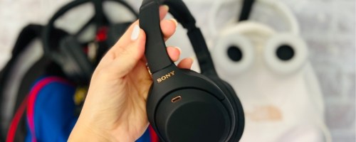hand holding a pair of black Sony headphones