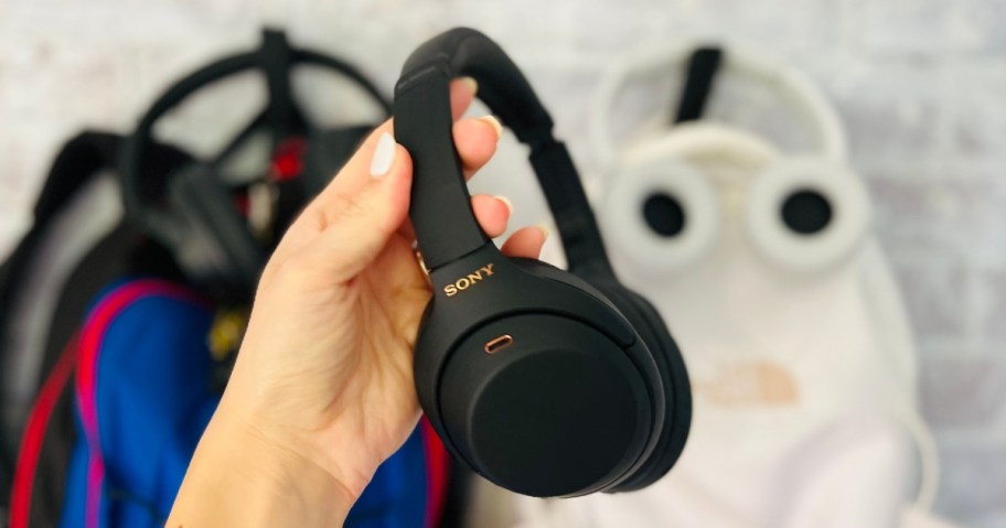 hand holding a pair of black Sony headphones