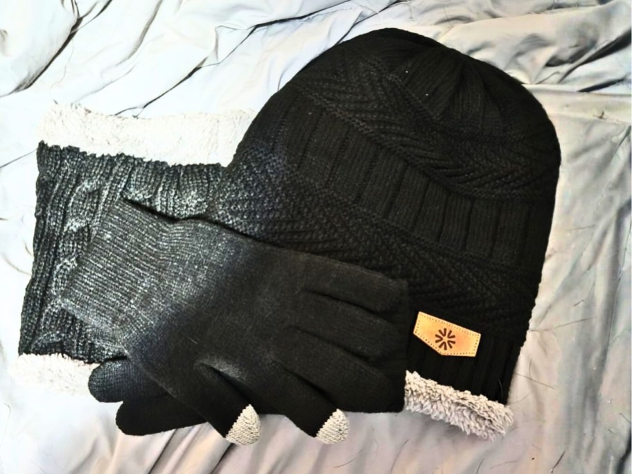 gloves, scarf and hat on a bed
