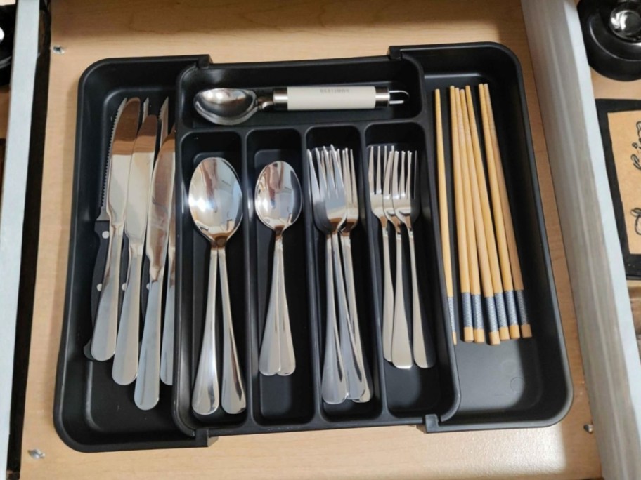 an expandable silverware drawer organizer in a drawer