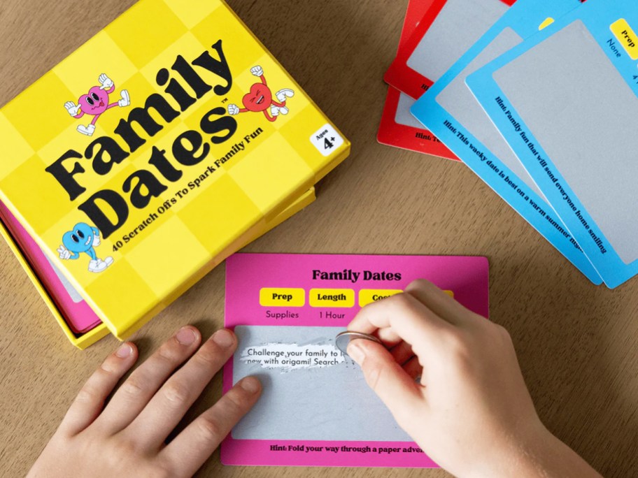hands scratching off family date idea card with box and more cards next to them